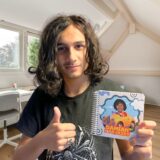 Personalizowana książka o pojazdach dla małego dziecka 1–3 lata. Sztywne strony, bindowanie na spirali - nastolatek trzyma swoją książkę ze swoim zdjęciem gdy był mały