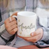 Personalizowany kubek dla dziewczynki z bajkową ilustracją księżniczki, imieniem i zdjęciem dziecka, otoczony motylami i kwiatami.